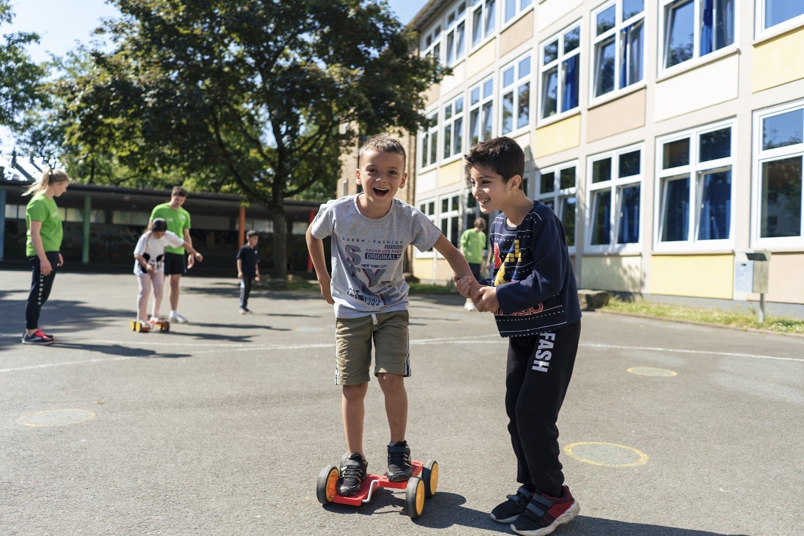 Zwei Jungen mit Balance-Board auf dem Schulhof